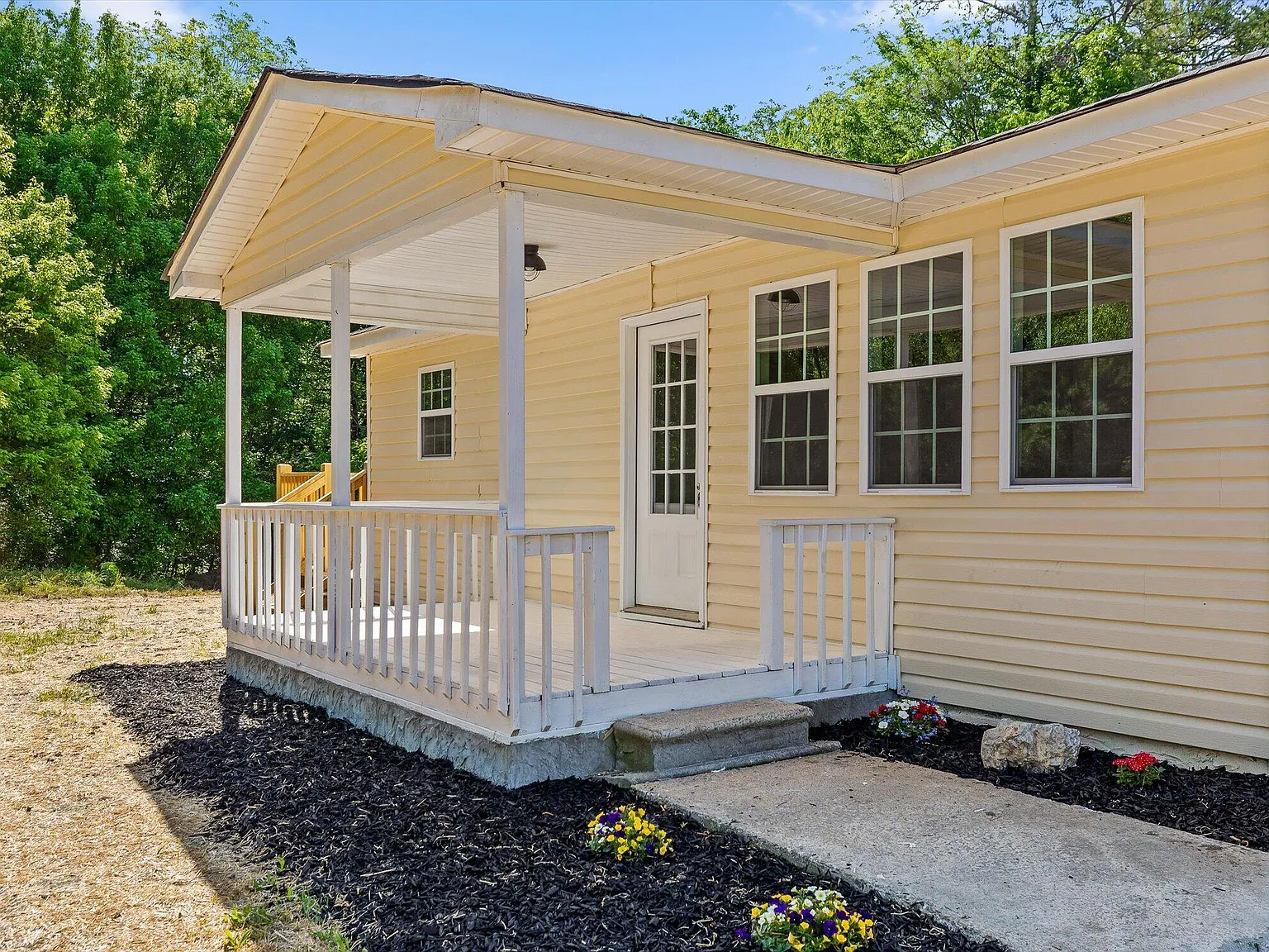 After: Fully renovated Harrison TN home with fresh exterior, new deck, and landscaping